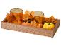 Herbstliches Holztablett mit zwei orangefarbenen Glas-Teelichthaltern, Ahornblättern und Kürbissen.