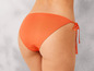 Ein orangefarbener Bikini-Slip mit Schleifen an den Seiten.