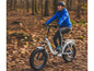 Eine Frau fährt mit einem weißen Myvelo E-Bike durch einen Wald.