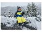 Lachender Junge in Winterkleidung und LUPILU® Kinder-Schneestiefeln auf einem verschneiten Stein.