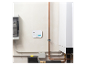Ein weißer Kohlenmonoxidmelder mit Digitalanzeige „000“ an einer Wand neben Kupferrohren und einem weißen Boiler.