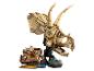 Ein großer beiger Lego Triceratops-Schädel mit einer Minifigur und einer Fossilienausgrabungsstätte.