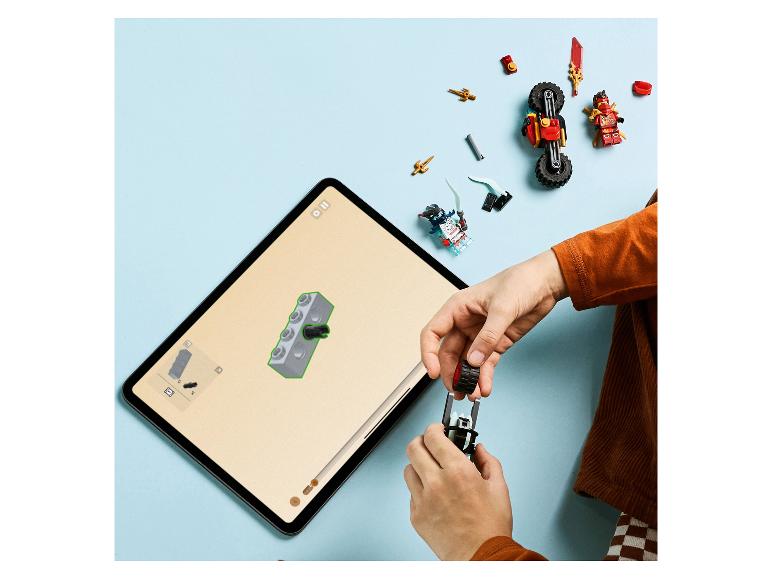 Kind baut ein LEGO Ninjago Set mit digitaler Anleitung auf einem Tablet.