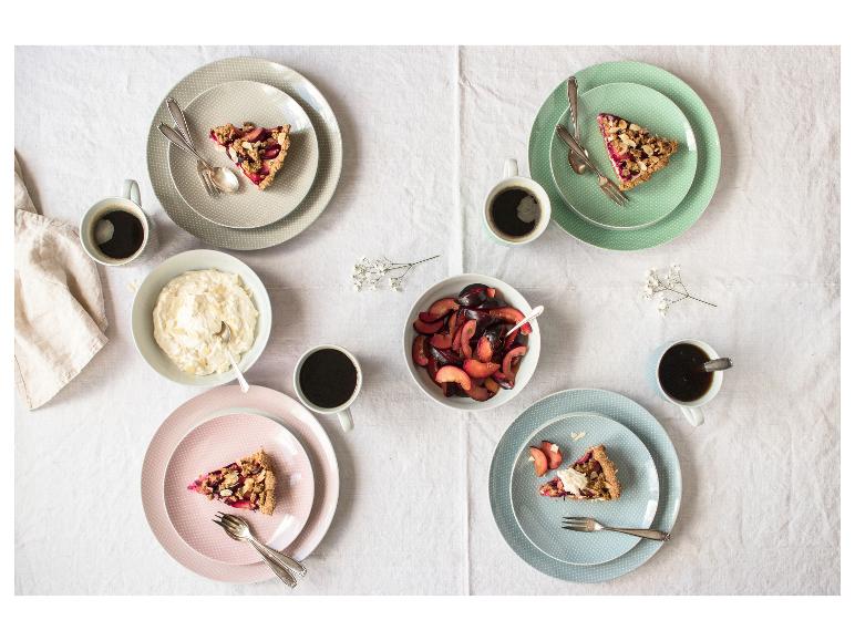 Aufnahme von oben eines Tisches mit Pflaumen-Crumble-Tarte, Kaffee und Obst.