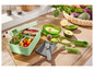 Eine grüne Lunchbox mit Salat und einem Avocado-Werkzeugset.