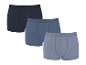 Drei gerippte Baumwoll-Boxershorts in Blau- und Grautönen.