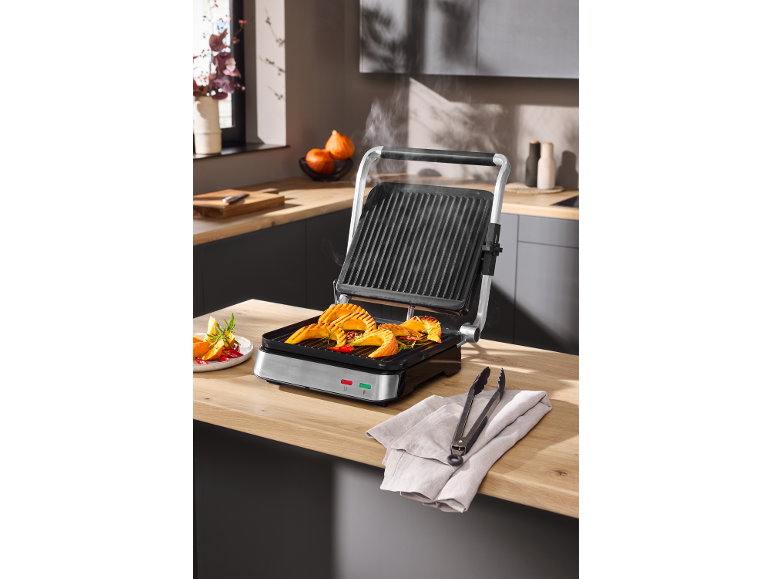 Elektrischer Kontaktgrill mit gegrilltem Kürbis auf einer Küchenarbeitsplatte.