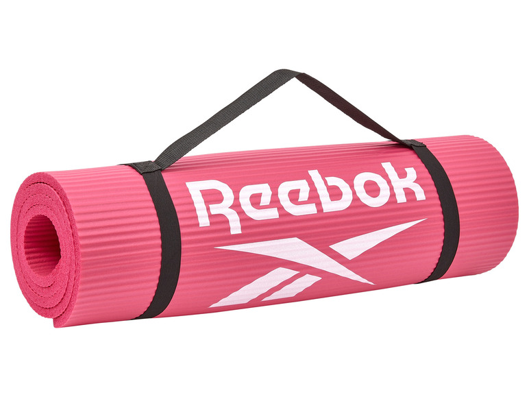 Eine rosa Yogamatte von Reebok mit Tragegurt.
