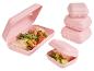 Rosa Brotdosen mit Wraps und Gurken, sowie ein Stapel geschlossener Dosen.