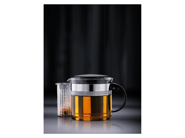 Glaskanne mit Teesieb, gefüllt mit bernsteinfarbenem Tee.