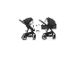 Zwei Kinderwagen mit Moskitonetz, einer sitzend, der andere liegend.
