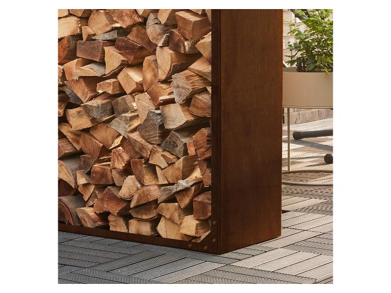 Holzstapel in Metallständer neben Topfpflanze auf Holzboden.