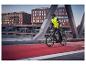 Mann in CRIVIT Thermo-Hybridjacke fährt Fahrrad auf einer Stadtbrücke.