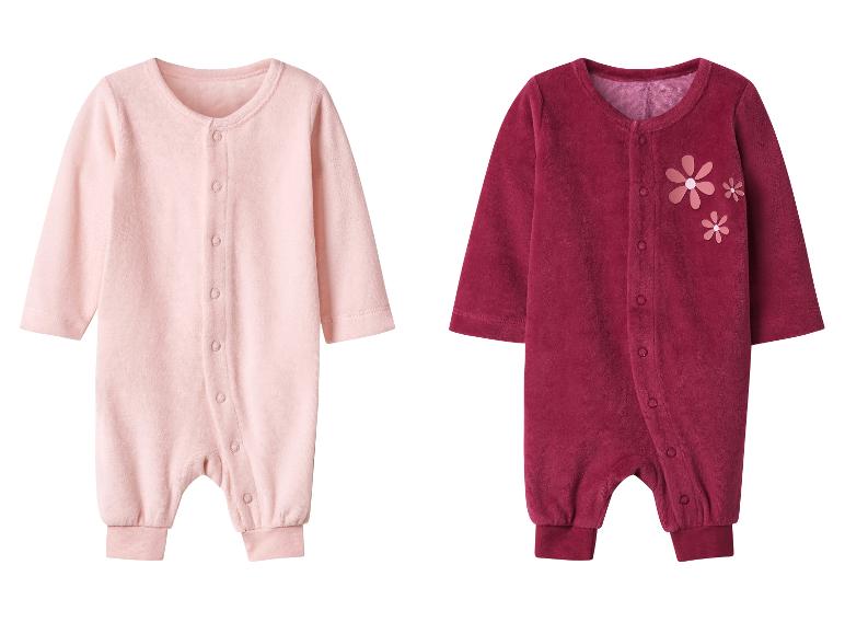 Zwei Baby-Strampler in Rosa und Bordeaux, letzterer mit Blumenapplikationen.