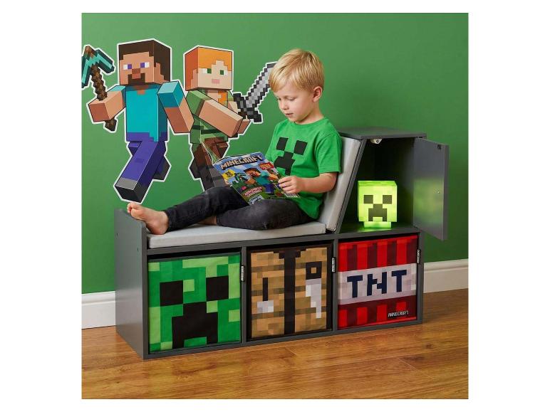 Kind liest auf einer Videospiel-Aufbewahrungsbank mit Wanddekoration und Lampe.