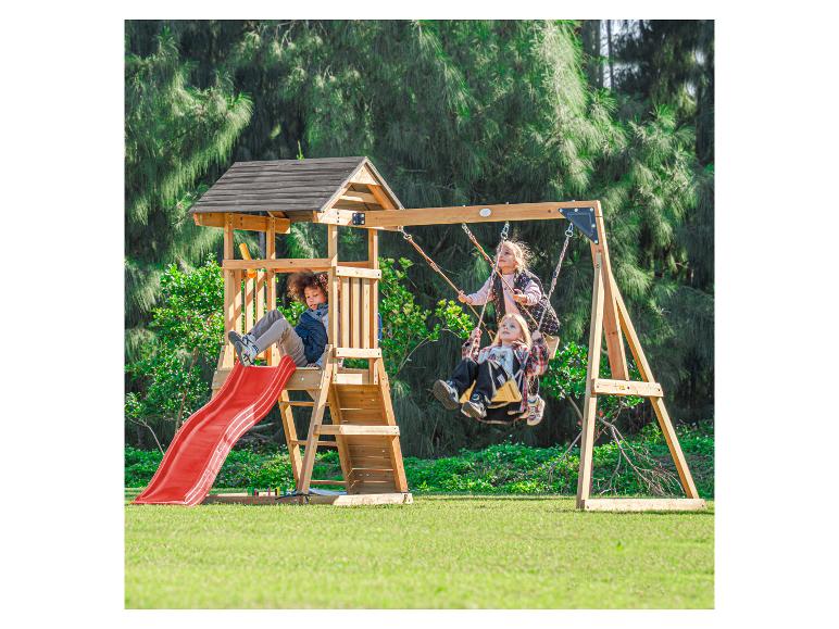 Kinder spielen auf einem Holzschaukelset mit roter Rutsche im Garten.