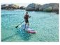 Lächelnder Mann auf einem Paddleboard im Meer, mit Schwimmweste und Paddel.