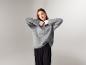 Frau in grauem ESMARA® Premium-Pullover aus Mohair-Mix und schwarzer Hose.