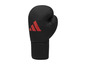 Ein schwarzer Boxhandschuh mit rotem Adidas-Logo.