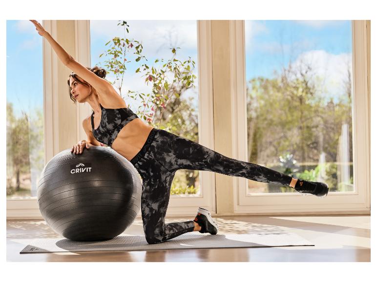 Eine Frau in CRIVIT Sporttights trainiert mit einem Gymnastikball.
