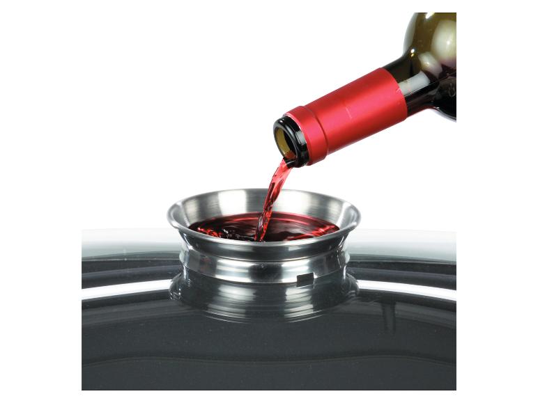 Eine Weinflasche wird in einen Metallbehälter gegossen.