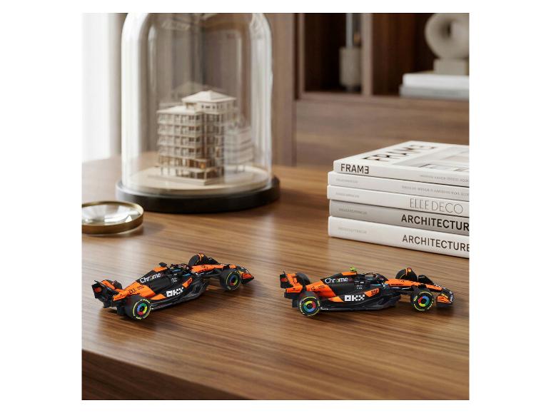 BBURAGO F1 Modellautos, 2er-Set, auf einem Holztisch mit Büchern und Dekoration.