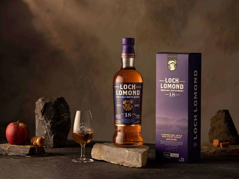 Flasche Loch Lomond 18 Jahre Whisky, neben einem Glas und einer Box.