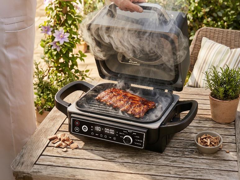 Geräucherte Rippchen auf einem elektrischen Außengrill mit Holzchips.