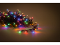 Bunte LED-Weihnachtsbeleuchtung, verflochten mit grünen Tannenzweigen, die lebendige Reflexionen werfen.