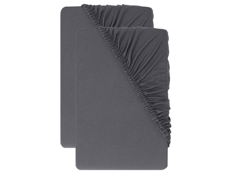 Zwei graue Spannbettlaken, gefaltet und hintereinander angeordnet