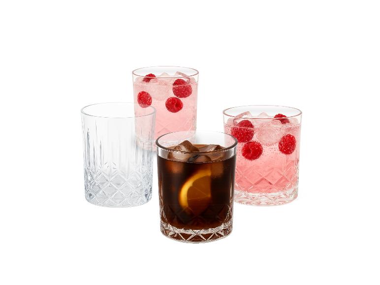 Vier Gläser, zwei mit rosa Getränk und Himbeeren, eines mit Cola und Zitrone, und eines leer.
