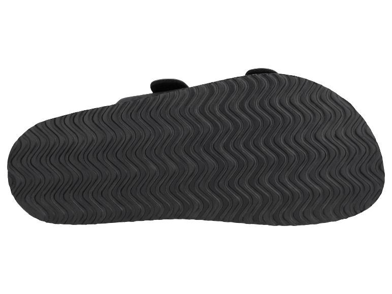 Schwarze Sandalensohle mit Wellenmuster, Unteransicht.