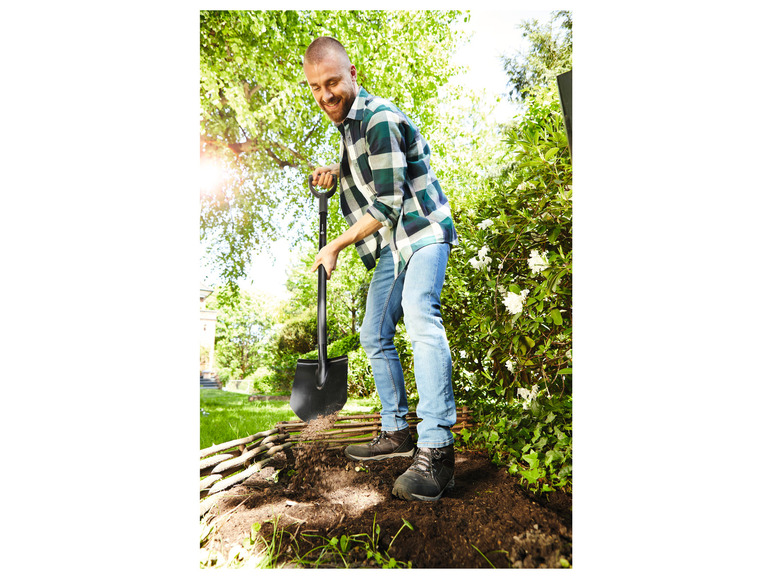 Ein Mann gräbt im Garten mit einer Schaufel.