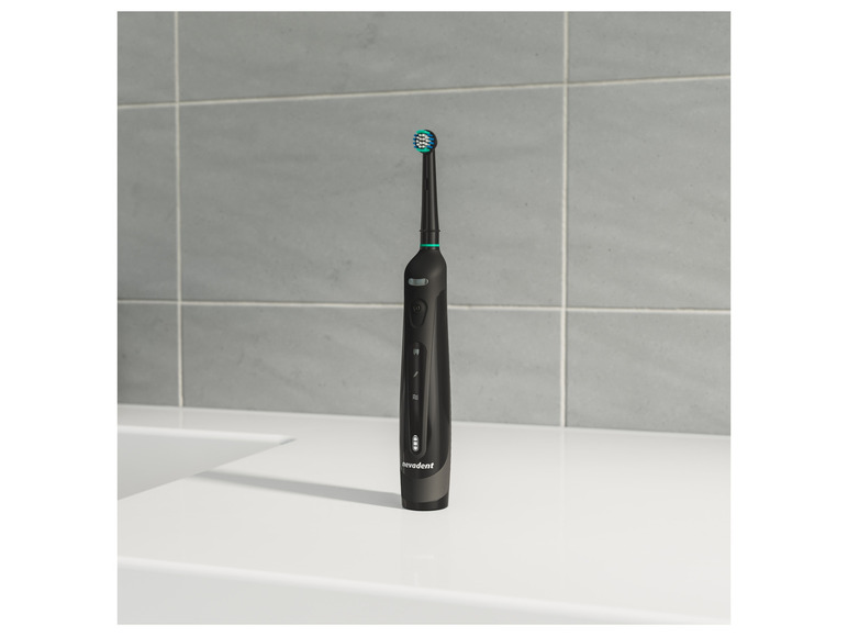 Eine schwarze elektrische Zahnbürste von Nevadent auf einem weißen Waschbecken.