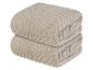 Zwei beige Handtücher mit einem gerippten Muster.