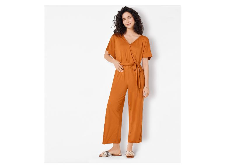 Eine Frau trägt einen orangefarbenen Jumpsuit mit Gürtel.
