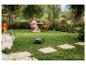 Frau mit Hund im Garten mit Mähroboter.