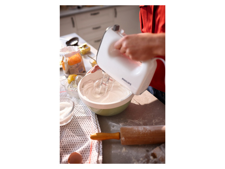Ein weißer Philips Handmixer schlägt Sahne in einer Schüssel.