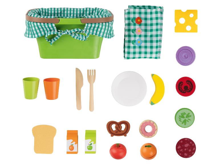 Spielzeug-Picknickkorb mit Essen und Geschirr.