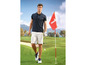Ein Golfer in einem Poloshirt und Shorts auf dem Golfplatz.
