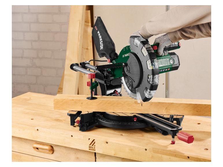 Eine Person schneidet Holz mit einer Kappsäge auf einer Werkbank.