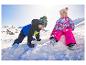 Zwei kleine Kinder in bunten LUPILU® Schneejacken spielen im Schnee