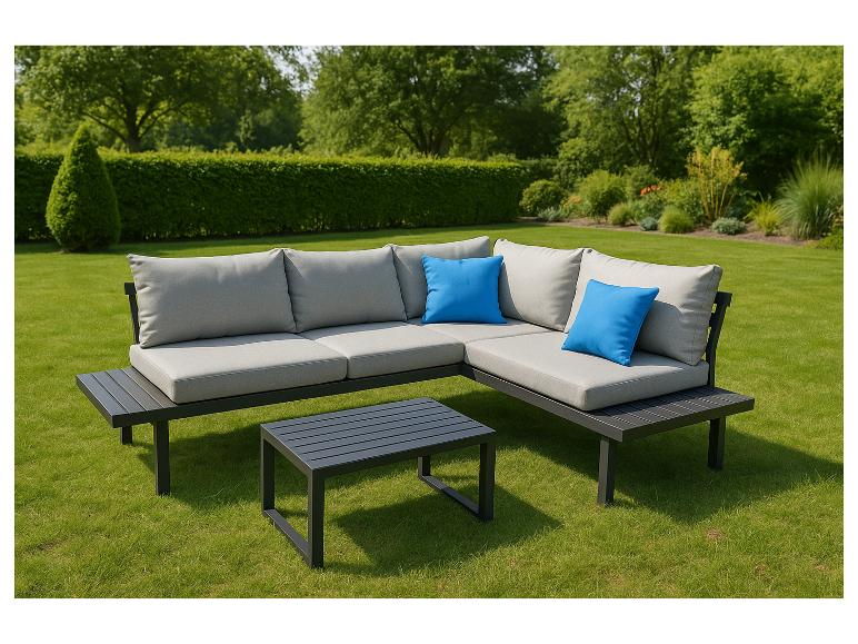 Graue Gartenlounge mit blauen Kissen und Couchtisch auf dem Rasen.