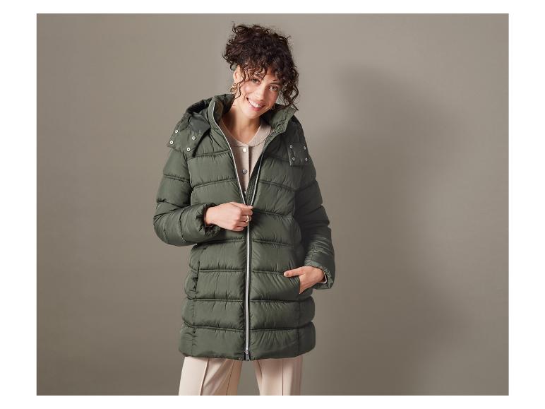 Eine Frau in einer grünen Daunenjacke mit Kapuze.