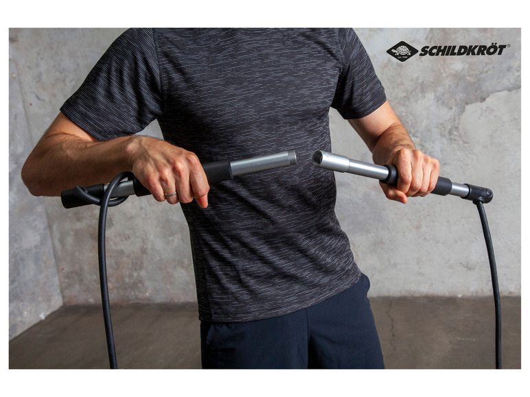 Ein Mann hält zwei auseinandergenommene Fahrradpumpen fest, Marke Schildkröt.