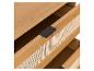 Helle Holzschublade mit schwarzem Griff und geflochtener Front.