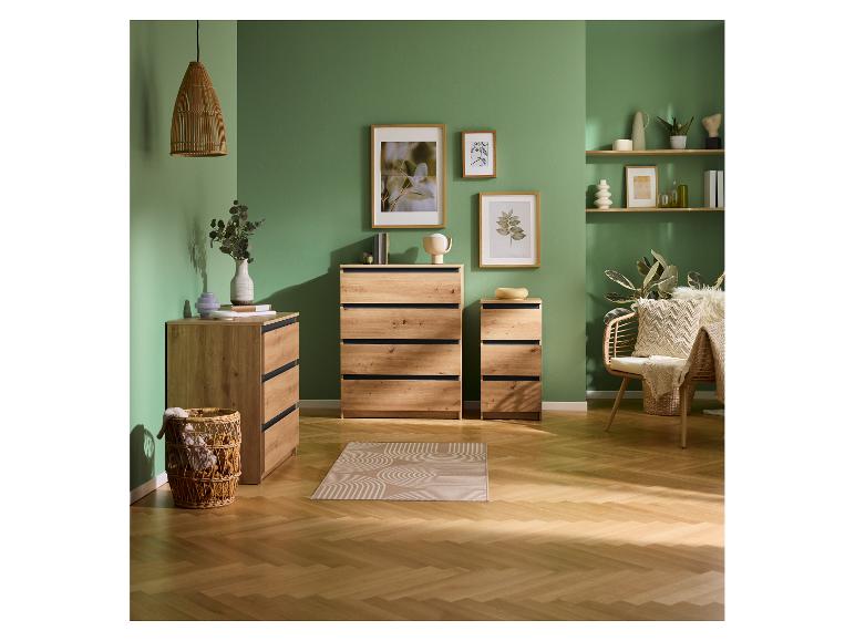 Holzkommoden und Regale in einem grünen Raum mit Rattanmöbeln und Dekorationen.