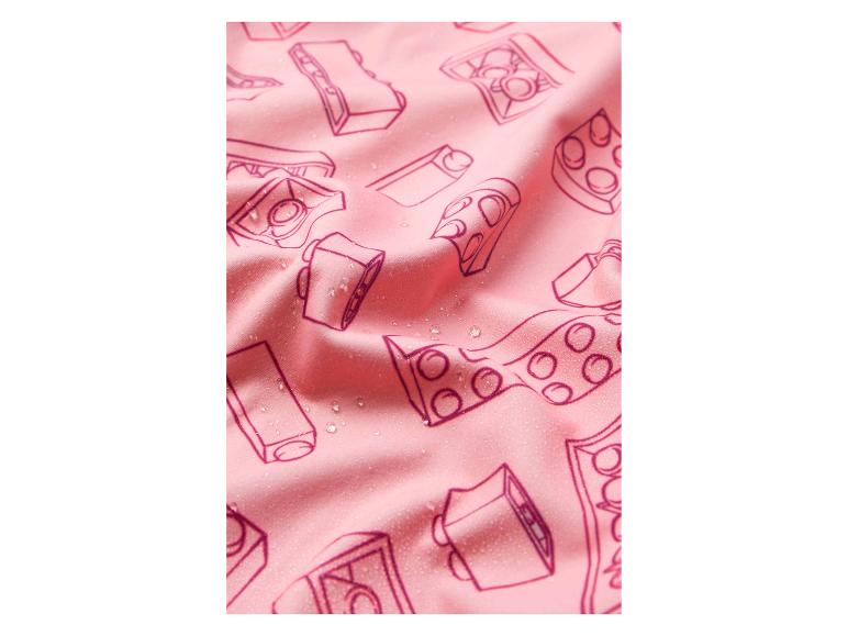 Rosa Stoff mit einem Muster aus Kameras und Spielzeugblöcken, mit Wassertropfen.