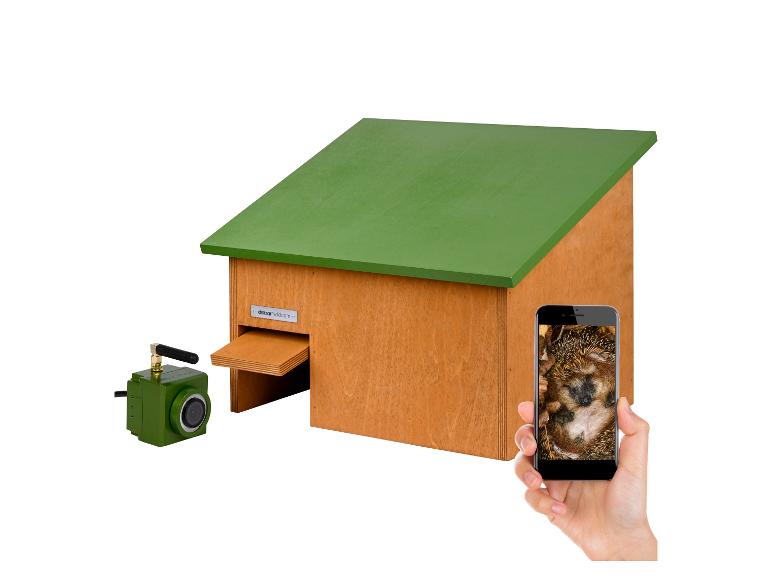 Holzhaus mit grünem Dach, Kamera und Smartphone, das einen Igel zeigt.