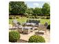 Rattan-Gartenmöbelset mit Sofa, Sesseln, Tisch und Fußhockern auf einer Terrasse.